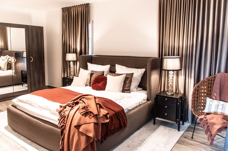 Einrichtungskonzept Schlafzimmer Einrichtung in warmen Farben I Schlafzimmer rote Decke Kissendekoration auf Bett Tischleuchte Inneneinrichtung Ideen Einrichtungsideen Kundenprojekt Einrichtungskonzept Interior Design Räume planen