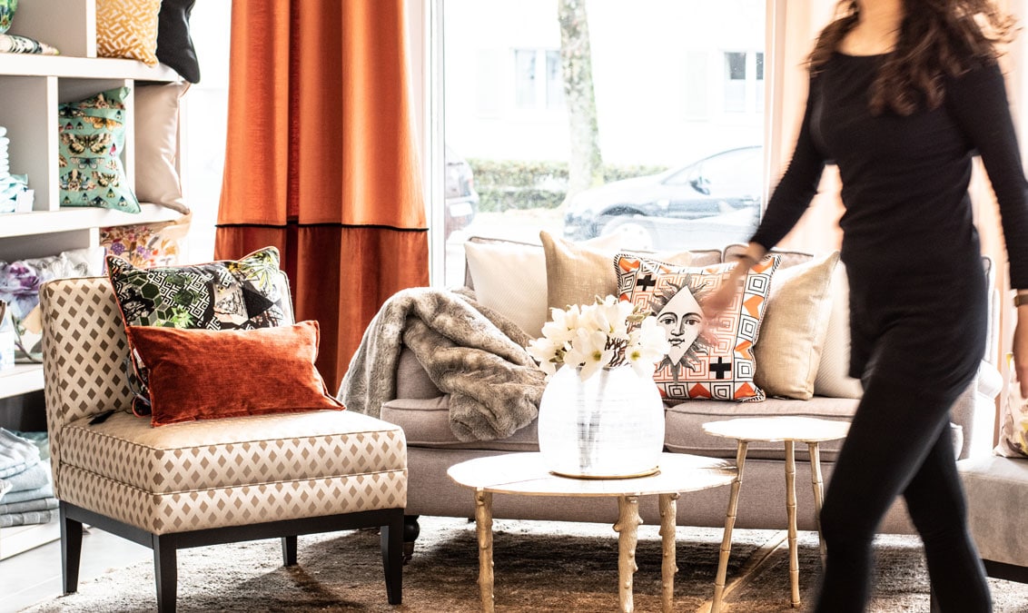 Showroom Einrichtungskonzept Wohnzimmer Kissendekoration auf Sofa Beistelltisch Blumendekoration Vasen roter Vorhang